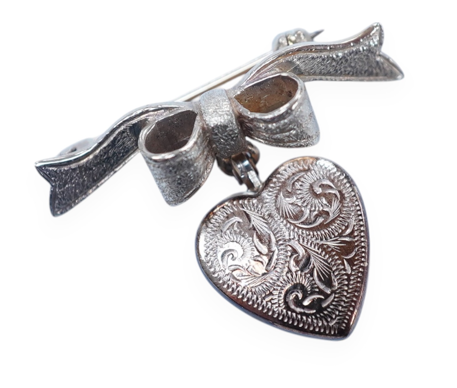 A modern engraved 9ct gold heart shaped locket, on an associated 9ct gold ribbon bow suspension brooch, width 31mm, gross weight 4.2 grams. Condition - fair to good